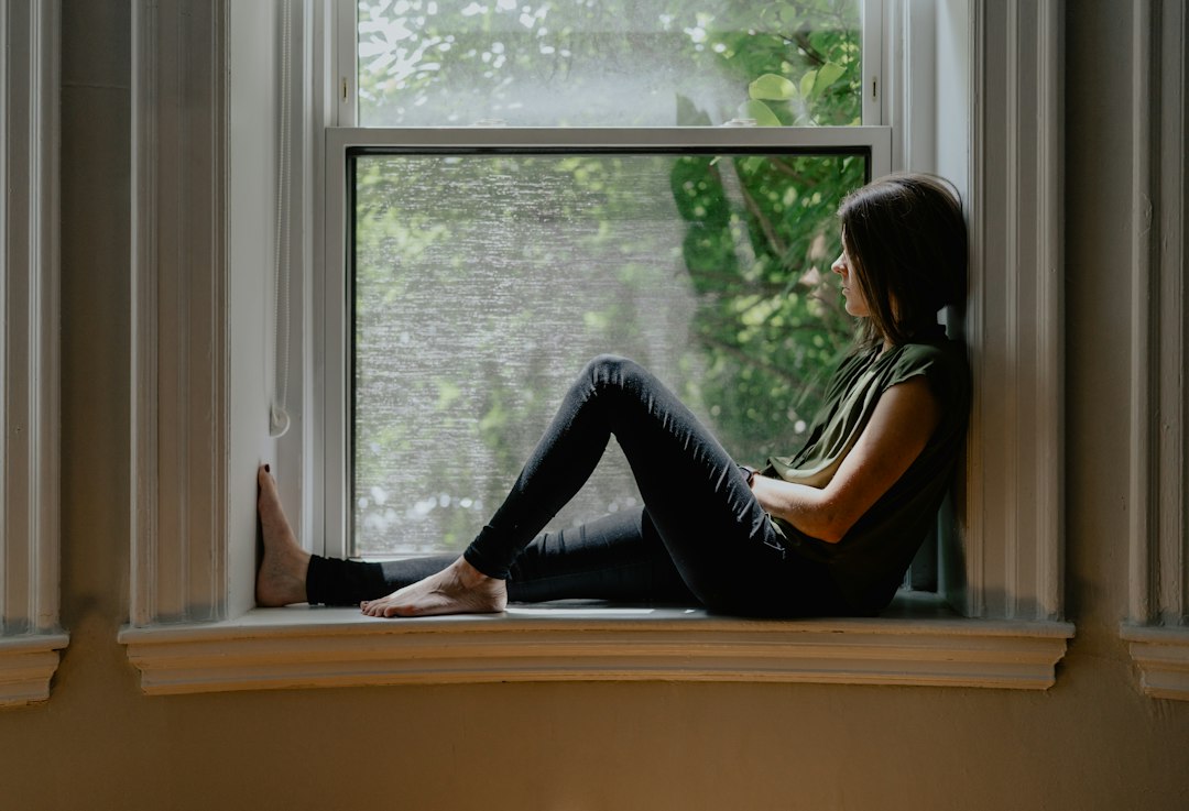 Woman sitting quietly by a window during an emotionally stressful moment
