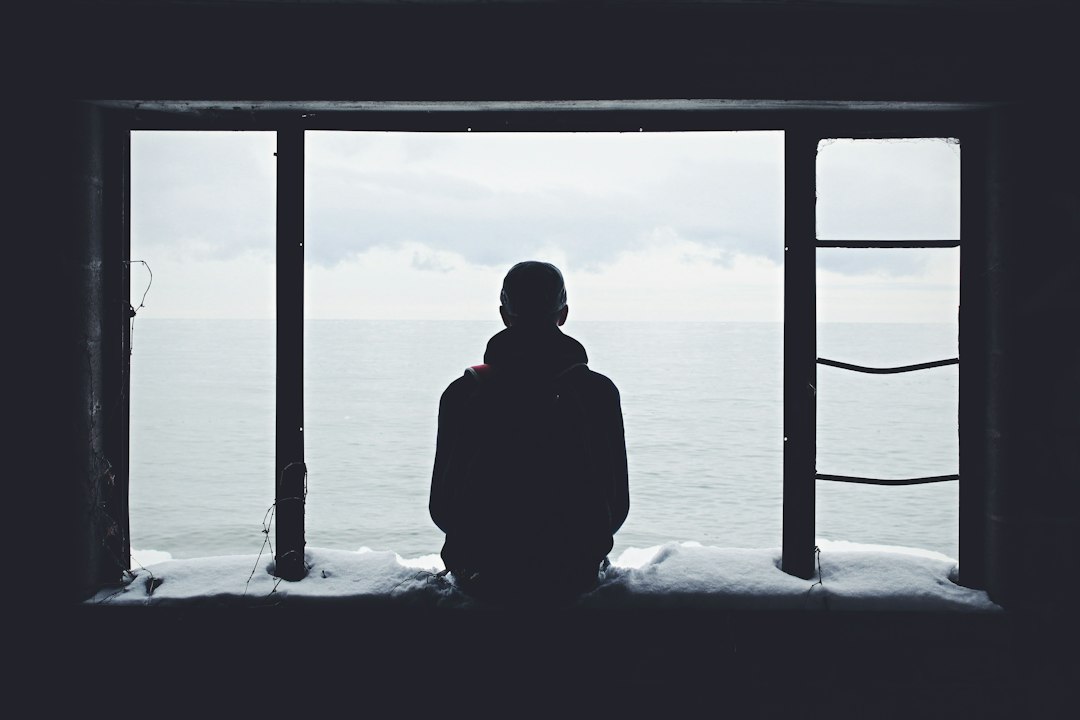 Person looking out a window in solitude